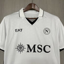Camisa Napoli Away II 2024/25 EA7 Torcedor Masculina branca com detalhes em azul e dourado, escudo em alto relevo e logo EA7 no peito, representando elegância, conforto e tradição napolitana.