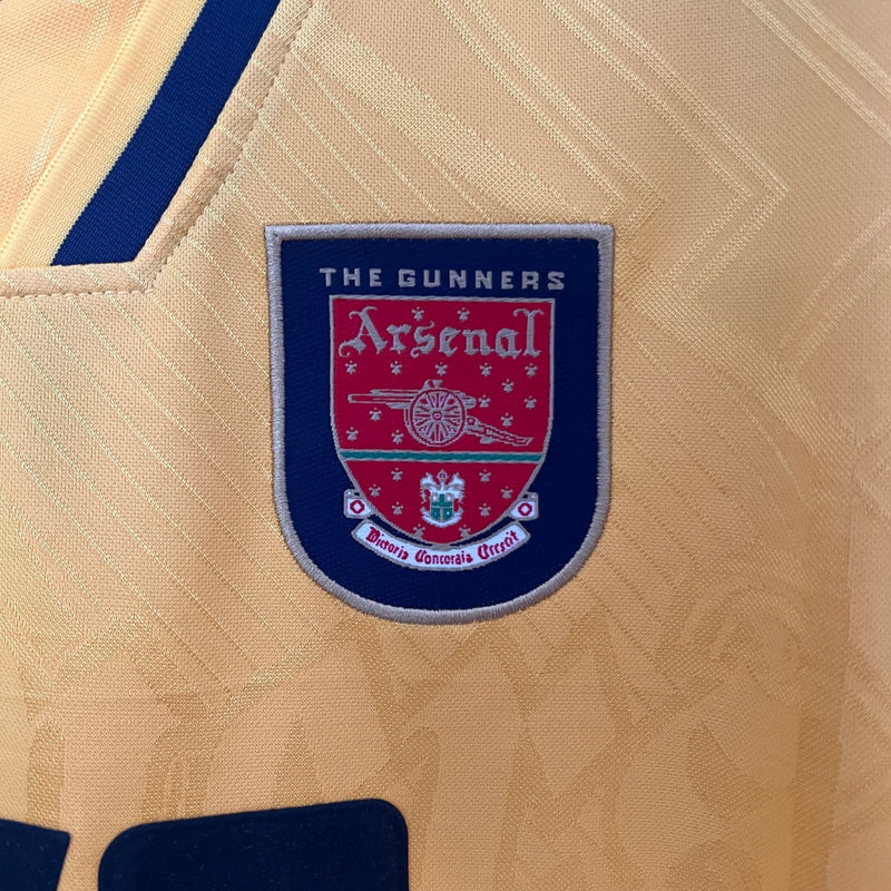 Camisa Arsenal Away II 1996/97 Nike Retrô Masculina amarela com detalhes em vermelho, gola clássica e escudo do Arsenal bordado, perfeita para colecionadores e fãs do futebol inglês."
