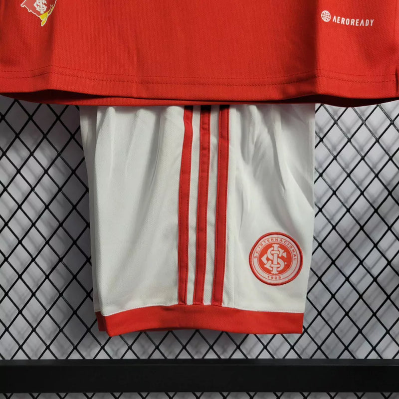 Kit Infantil Internacional Home 2022/23 Adidas na cor vermelha com shorts branco, uniforme oficial para crianças com escudo do Inter e logo Adidas, tecido leve e confortável.