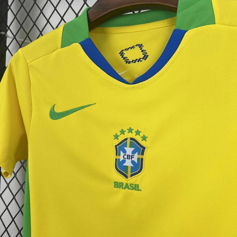 Kit Infantil Brasil Home 2025/26 Nike, camisa amarela com detalhes em azul e verde, shorts e meias combinando, uniforme oficial para crianças de 3 a 13 anos torcedoras da Seleção Brasileira."