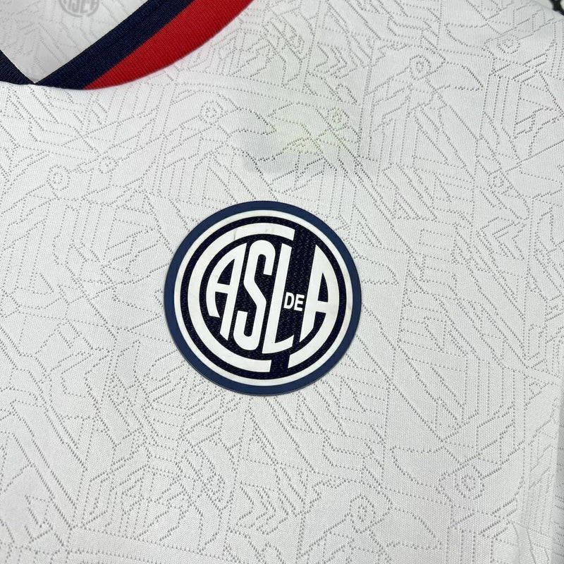 Camisa San Lorenzo Away II 2025/26 Torcedor Masculina branca com detalhes em azul e vermelho, escudo estampado do clube argentino e design moderno para torcedores."