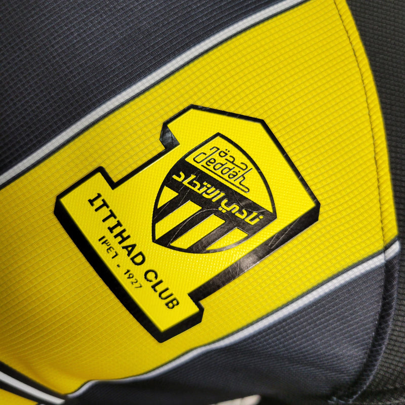 Camisa Al-Ittihad Home I 2023/24 Nike Jogador Masculina preta e amarela, modelo player com listras verticais, tecnologia Dri-FIT ADV e escudo do Al-Ittihad no peito – uniforme titular da temporada 23/24.