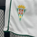 Kit Infantil Córdoba CF Home (1) 2025/26, camisa verde e branca com shorts oficiais, disponível dos tamanhos 3-4 anos até 12-13 anos, uniforme completo para pequenos torcedores."