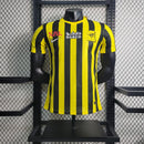"Camisa Al-Ittihad Home I 2022/23 Nike Jogador Masculina na cor amarela com detalhes em preto, versão player slim fit, tecnologia Dri-FIT ADV, escudo em TPU premium – uniforme titular do Al-Ittihad Club da Arábia Saudita."