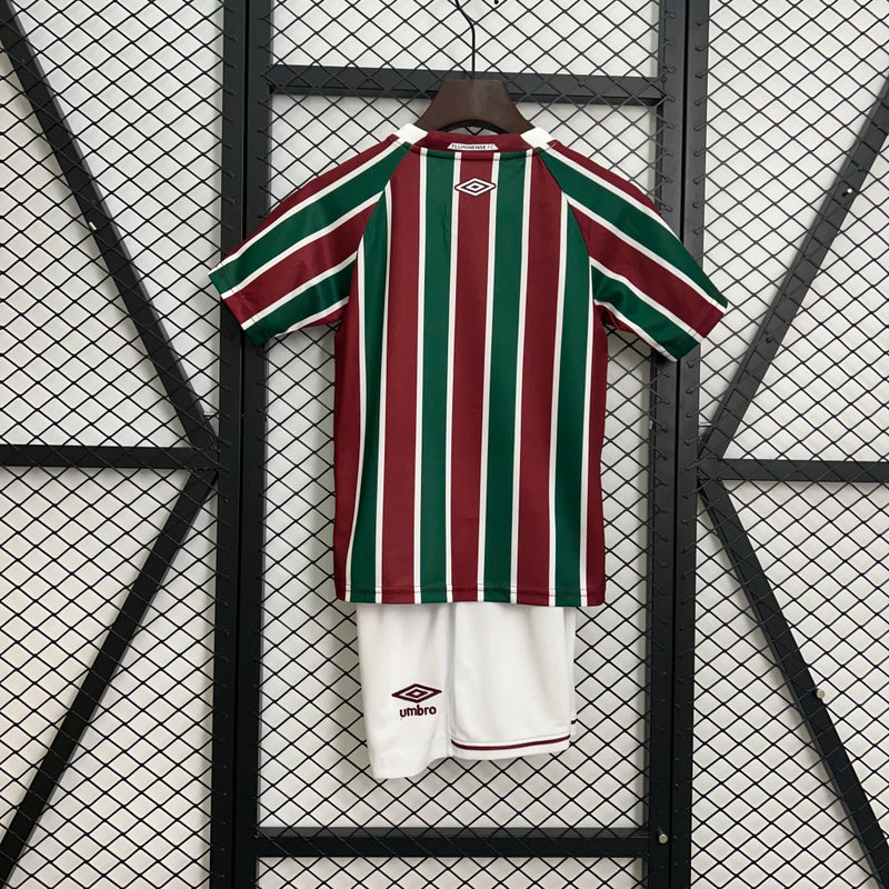 Kit Infantil Fluminense Home 2025/26 Umbro, camisa tricolor verde, grená e branca com shorts e meias combinando, uniforme oficial para crianças de 3 a 13 anos torcedoras do Fluminense."