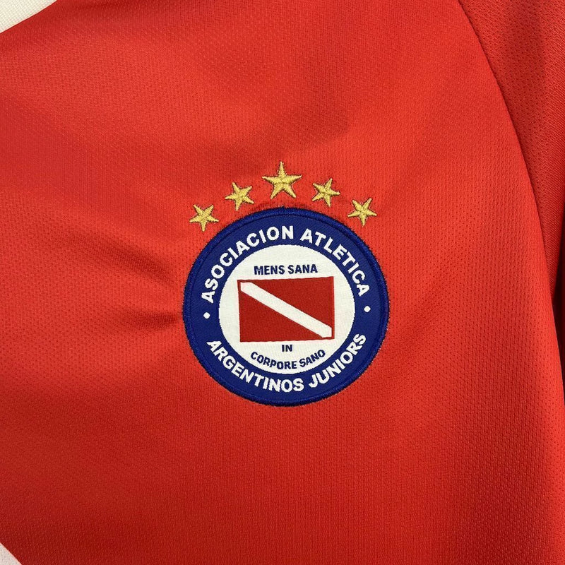 Texto alternativo para imagem:
Camisa Argentinos Juniors Home 2025/26 Umbro Torcedor Masculina vermelha com detalhes brancos, escudo do clube no peito e logo Umbro bordado.

