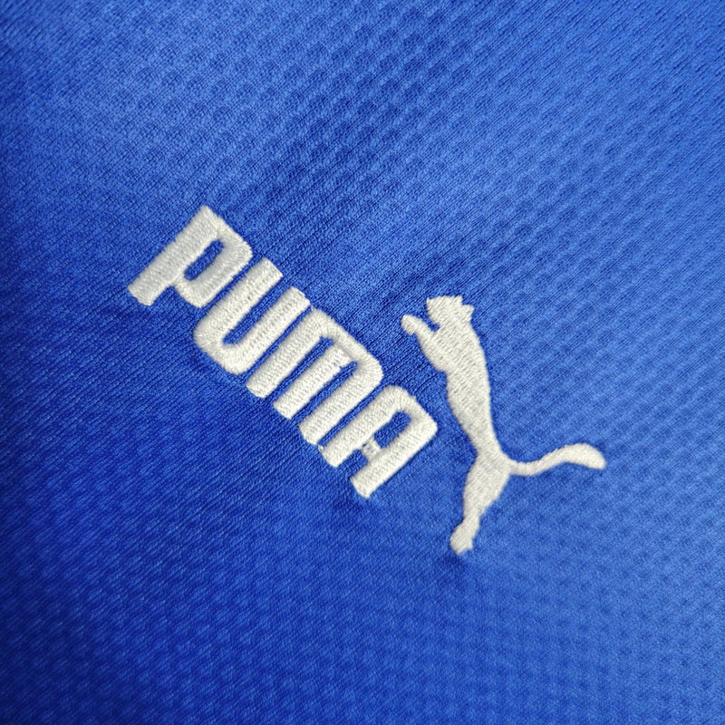 "Camisa Islândia Home I 2022/23 Puma masculina azul com detalhes em branco e vermelho, gola careca, mangas curtas e tecido leve respirável para torcedores"