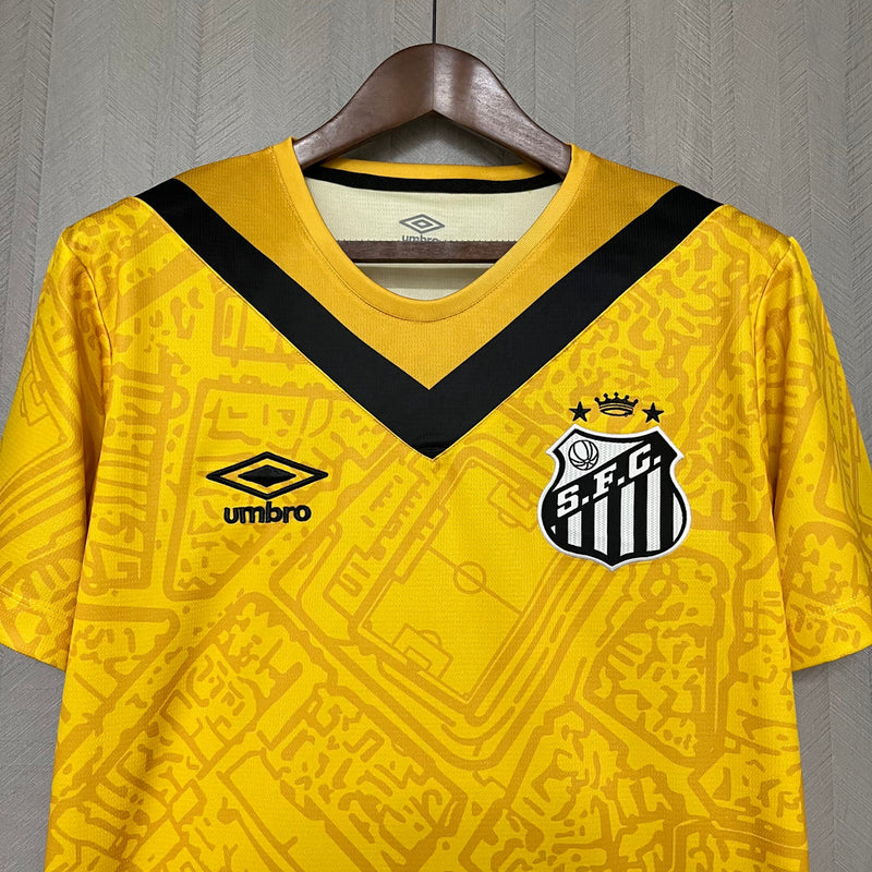 Camisa Santos III 2024/25 Umbro Torcedor Masculina – modelo na cor amarela com detalhes em preto, escudo do Santos FC bordado no peito esquerdo e logo da Umbro bordado no lado direito, design moderno e esportivo.