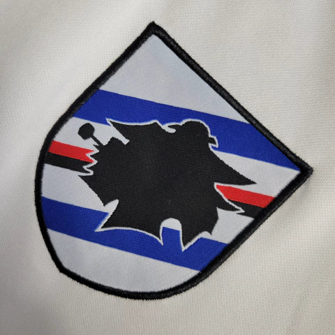 Camisa Sampdoria Away II 2022/23 Torcedor Masculina Branca com faixas azul, vermelha e preta no peito, escudo bordado e design clássico do clube italiano