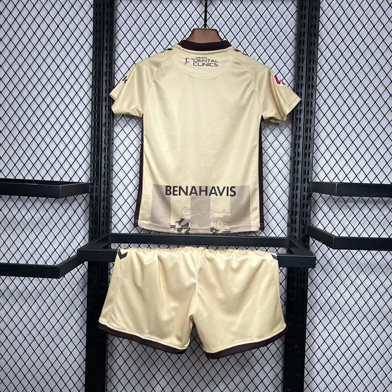 Kit Infantil Málaga CF Third III 2024/25 Hummel com camisa e short dourados, uniforme infantil leve e respirável, ideal para jogos, treinos e jovens torcedores do Málaga CF."