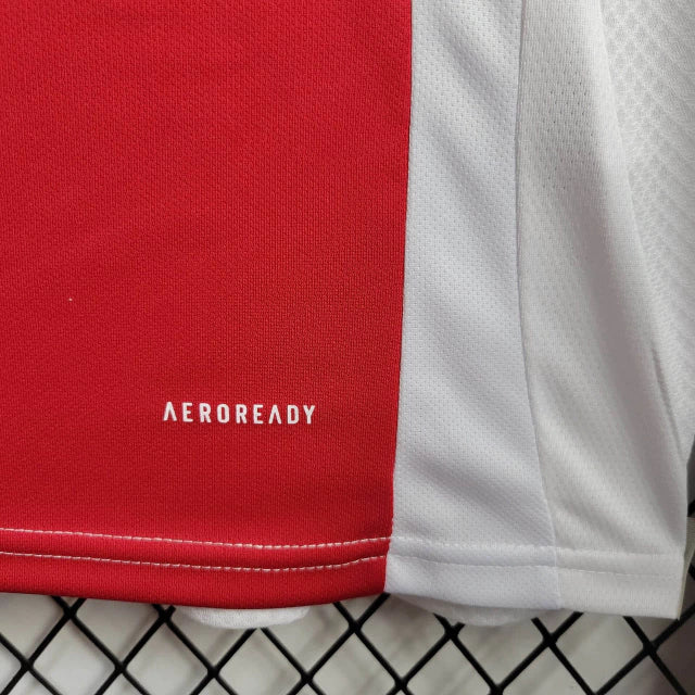 "Camisa Ajax Home (1) 2024/25 Adidas Torcedor Masculina oficial, branca com faixa vermelha central, escudo bordado e logo Adidas, versão torcedor da temporada 24/25."