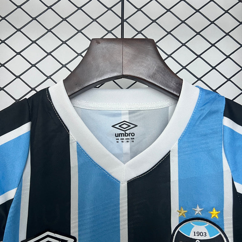 "Kit Infantil Grêmio Home 2024/25 Umbro, camisa azul, preta e branca listrada com shorts e meias combinando, uniforme oficial para crianças de 3 a 13 anos torcedoras do Grêmio."