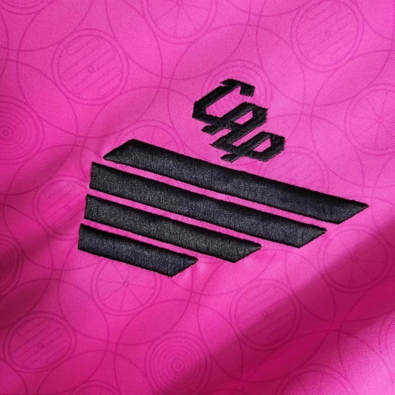 Camisa Athletico Paranaense Outubro Rosa 2023/24 Umbro Torcedor Masculina rosa vibrante com escudo oficial bordado e logo Umbro estampado, edição especial de conscientização contra o câncer de mama.