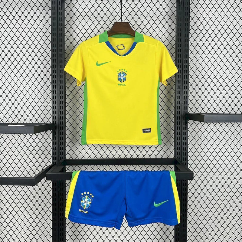 Kit Infantil Brasil Home 2025/26 Nike, camisa amarela com detalhes em azul e verde, shorts e meias combinando, uniforme oficial para crianças de 3 a 13 anos torcedoras da Seleção Brasileira."