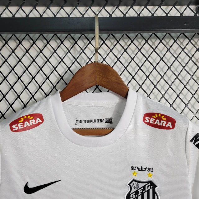 Kit Infantil Santos Home 2012/13 Nike Retrô – uniforme infantil oficial com camisa branca clássica, escudo bordado do Santos FC e short, ideal para pequenos torcedores e colecionadores.
