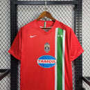 Camisa Juventus Away II 2005/06 Nike Retrô Masculina vermelha, escudo da Juventus bordado no peito, gola redonda clássica e detalhes em preto e branco.