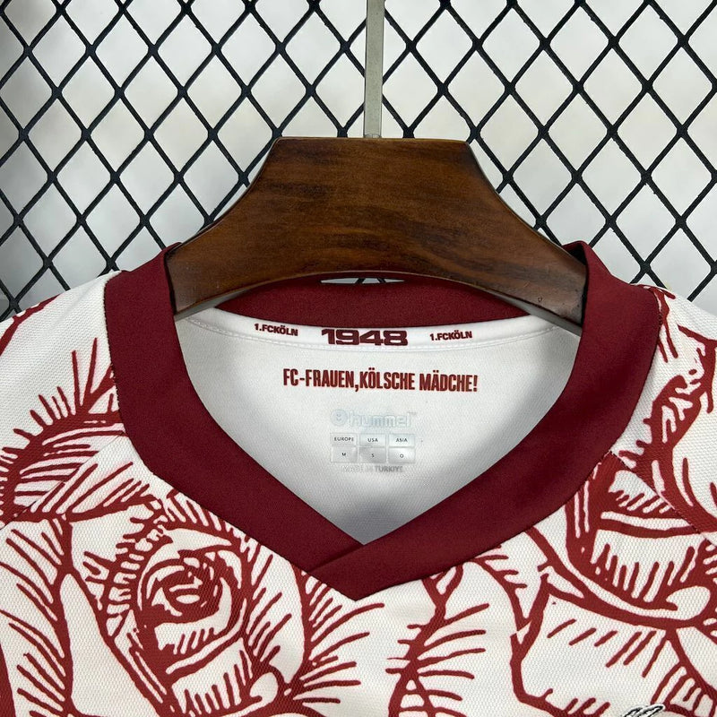Camisa 1. FC Köln 'Kölsch Mädche' 2024/25 Hummel Torcedor Masculina branca com detalhes vermelhos e pretos, escudo bordado do clube e logo Hummel, modelo oficial para torcedores do futebol alemão.