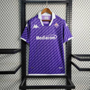 Camisa Fiorentina Home I 2023/24 Kappa Torcedor Masculina roxa com escudo bordado no peito, logo Kappa em destaque nos ombros, gola redonda moderna e tecido leve e respirável, perfeita para torcedores que valorizam estilo, conforto e tradição do clube italiano.