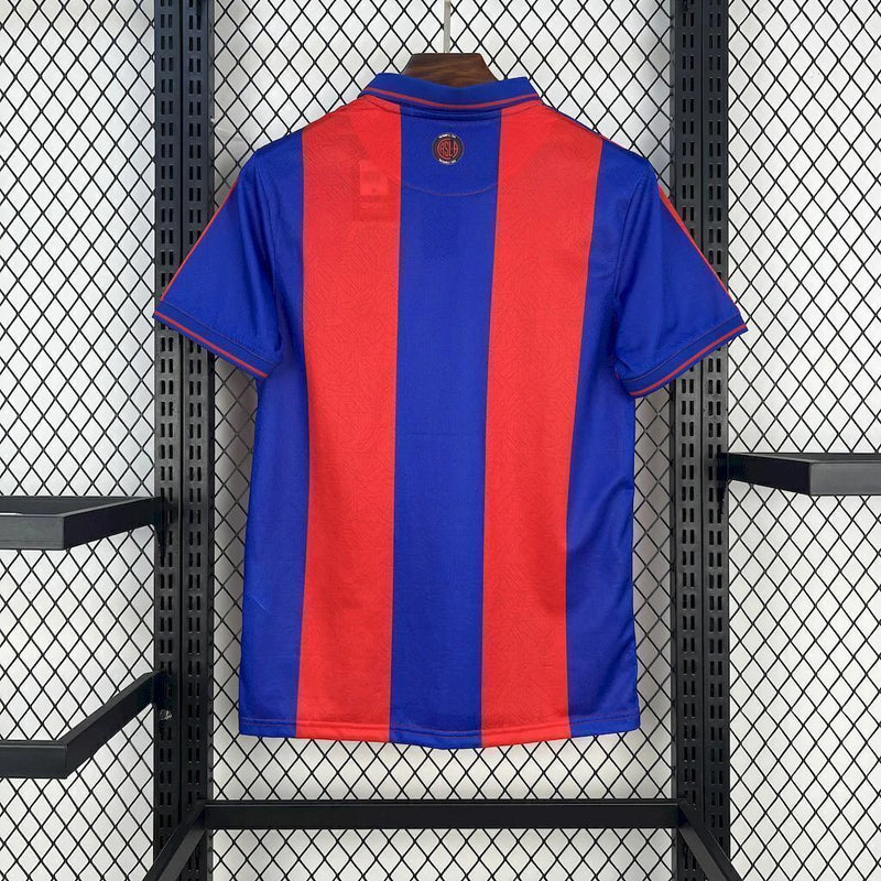 Camisa San Lorenzo Home I 2025/26 Torcedor Masculina azul com detalhes em vermelho, escudo estampado do clube argentino e tecido leve e respirável para torcedores."