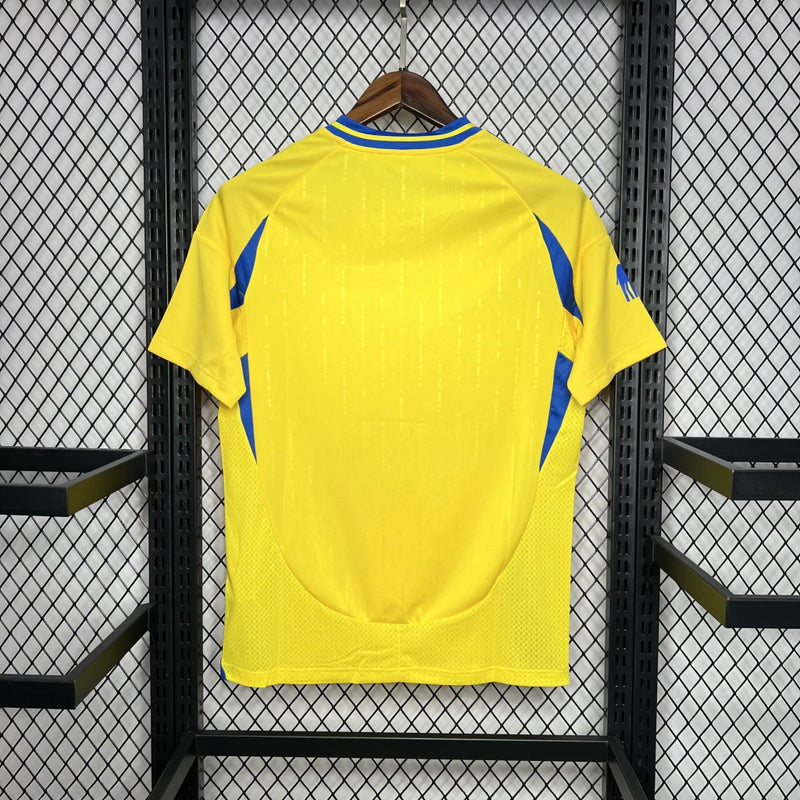 Camisa Al-Nassr Home (1) 2024/25 Adidas Torcedor Masculina na cor amarela com detalhes em azul, escudo do Al-Nassr aplicado no peito e logo Adidas bordado, modelo oficial da temporada 2024/25."
