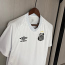 Camisa Santos Home I 2025/26 Umbro Torcedor Masculina branca, com escudo do Santos bordado no lado esquerdo do peito e logo Umbro no lado direito, modelo de jogo, versão torcedor, fundo branco.