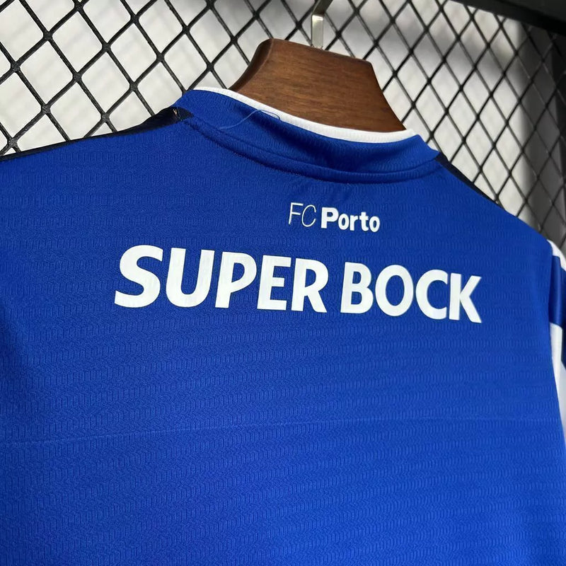 Kit Infantil FC Porto Home I 2024/25 New Balance, camisa azul e branca com listras verticais, escudo oficial do clube, tecido leve e confortável, conjunto completo com shorts para crianças de 3 a 13 anos
