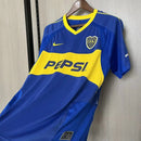 Camisa Boca Juniors Home I 2003/04 Nike Retrô Masculina azul com faixa amarela horizontal, escudo bordado e design clássico inspirado na temporada histórica do clube argentino."