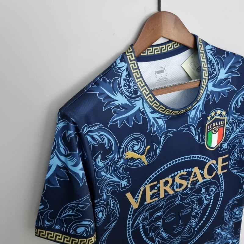 Camisa Concept Itália x Versace Puma Torcedor masculina, azul, com escudo da seleção italiana no peito, detalhes exclusivos da Versace e três listras Puma nos ombros, feita em tecido leve e respirável, modelo com caimento confortável, ideal para torcer com estilo e exclusividade.”