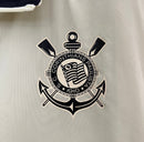 Detalhe da camisa Nike Corinthians 110 Anos 2023 bege com escudo do clube e tecido tecnológico.