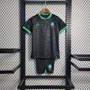 Kit Infantil Brasil 2023/24 Nike, camisa preta com detalhes em verde, shorts e meias combinando, uniforme oficial para crianças de 3 a 13 anos torcedoras da Seleção Brasileira."
