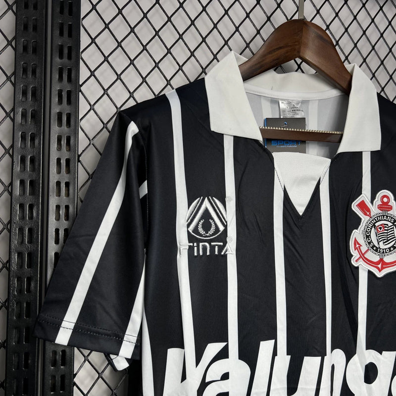 Camisa Corinthians away 1990/91 finta retro masculina com listras verticais em preto e branco, gola polo preta e escudo Bordado mó peito modelo clássico dos anos 90