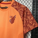 Camisa Athletico Paranaense Treino 2024/25 Umbro Torcedor Masculina laranja vibrante com escudo oficial bordado e logo Umbro estampado, modelo  de treino do clube paranaense.
