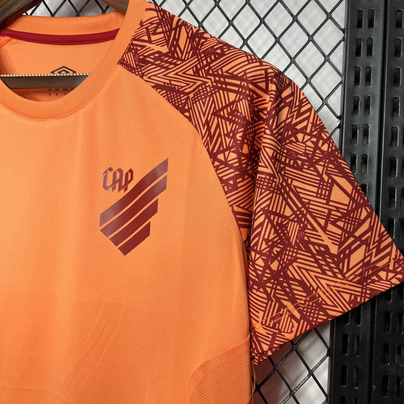 Camisa Athletico Paranaense Treino 2024/25 Umbro Torcedor Masculina laranja vibrante com escudo oficial bordado e logo Umbro estampado, modelo oficial de treino do clube paranaense.