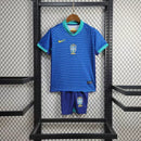 "Kit Infantil Brasil Away 2024/25 Nike, camisa azul com detalhes em verde e amarelo, shorts e meias combinando, uniforme oficial da Seleção Brasileira para torcedores mirins."