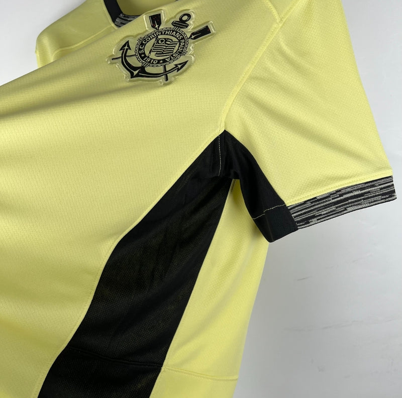 Camisa Corinthians Third III 2023/24 Nike torcedor masculina amarela, com escudo do clube bordado no peito, detalhes em preto e design inspirado na Democracia Corinthiana
