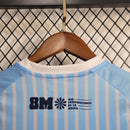 "Kit Infantil Uruguai Home (1) 2024/25 oficial, camisa celeste com escudo da AUF em destaque, shorts combinando, uniforme completo para crianças de 3 a 13 anos"
