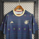 Camisa Jamaica Pré-Jogo 2023/24 Adidas Torcedor Masculina, azul, com escudo da seleção jamaicana e logo Adidas em destaque, confeccionada em tecido leve e respirável, modelo masculino com caimento confortável, ideal para treinos, jogos e uso casual.”