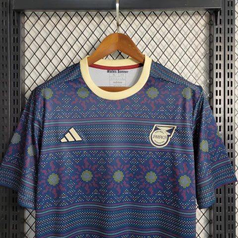 Camisa Jamaica Pré-Jogo 2023/24 Adidas Torcedor Masculina, azul, com escudo da seleção jamaicana e logo Adidas em destaque, confeccionada em tecido leve e respirável, modelo masculino com caimento confortável, ideal para treinos, jogos e uso casual.”