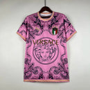 Camisa Concept Itália x Versace Puma Torcedor masculina, rosa, com escudo da seleção italiana no peito, detalhes exclusivos da Versace e três listras Puma nos ombros, feita em tecido leve e respirável, modelo com caimento confortável, ideal para torcer com estilo e exclusividade.