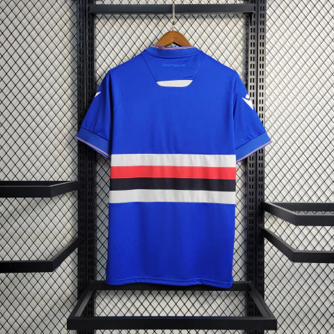 Camisa Sampdoria Home I 2022/23 Torcedor Masculina Azul com faixas branca, vermelha e preta no peito, escudo bordado e design clássico do clube italiano.”