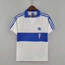 Camisa Universidad Católica Home I 1984/85 Adidas Retrô Masculina branca, modelo clássico dos anos 80 com detalhes em azul, escudo bordado e design histórico do futebol chileno.