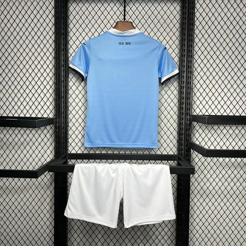 Kit Infantil Lazio Home I 2024/25 oficial, camisa celeste com escudo da Lazio em destaque, shorts combinando, uniforme completo para crianças de 3 a 13 anos"