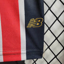 Kit Infantil São Paulo FC Away 2024/25 New Balance com camisa branca, detalhes em vermelho e preto, escudo bordado do SPFC, shorts combinando, uniforme oficial para crianças de 3 a 13 anos, torcedor infantil, conforto e mobilidade, peça licenciada"