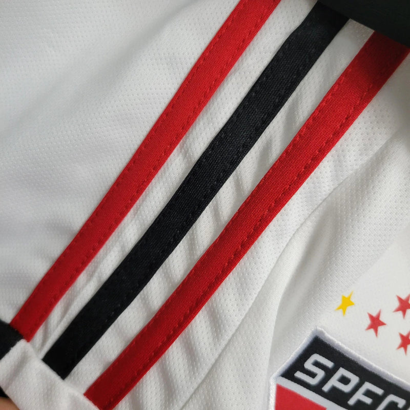 Kit Infantil São Paulo Home 2023/24 Adidas – Camisa branca com faixas vermelha e preta, short incluso, uniforme oficial infantil do SPFC com tecnologia AEROREADY."
