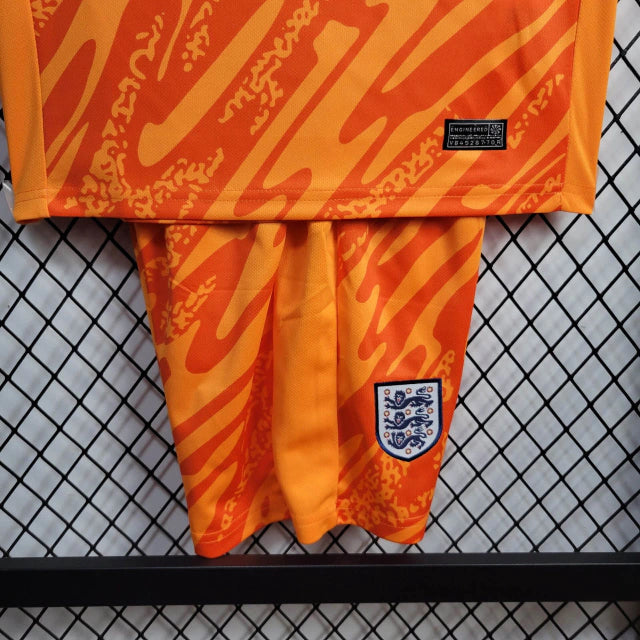 Kit Infantil Inglaterra Goleiro 2024/25 Nike na cor laranja vibrante, com camisa e shorts oficiais, escudo bordado da seleção inglesa e tecnologia Dri-FIT para máximo conforto."
