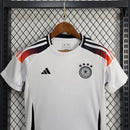 "Kit Infantil Alemanha Home 2024/25 Adidas – camisa branca com detalhes em preto e vermelho e shorts combinando, uniforme infantil oficial da seleção alemã, leve, respirável e confortável para crianças de 3 a 13 anos."
