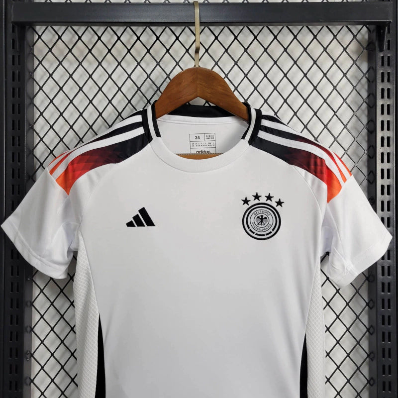 "Kit Infantil Alemanha Home 2024/25 Adidas – camisa branca com detalhes em preto e vermelho e shorts combinando, uniforme infantil oficial da seleção alemã, leve, respirável e confortável para crianças de 3 a 13 anos."
