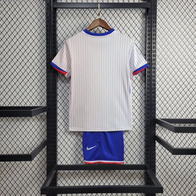 Kit Infantil França Away 2024/25 Nike – camisa azul escuro com detalhes em vermelho e branco e shorts combinando, uniforme infantil oficial da seleção francesa, leve, respirável e confortável para crianças de 3 a 13 anos."