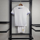 Kit Infantil Uruguai Away (2) 2024/25 – Camisa branca com detalhes em azul celeste e shorts oficial, uniforme leve, confortável e ideal para crianças de 3 a 13 anos."