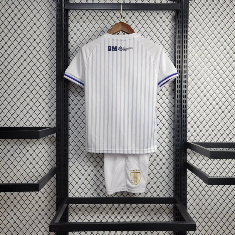 Kit Infantil Uruguai Away (2) 2024/25 – Camisa branca com detalhes em azul celeste e shorts oficial, uniforme leve, confortável e ideal para crianças de 3 a 13 anos."